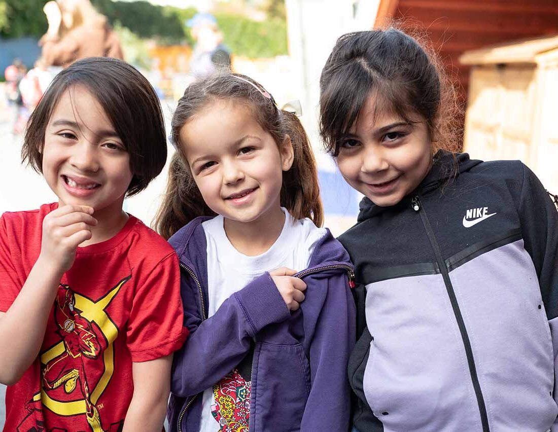 Three kindergarten students smiling